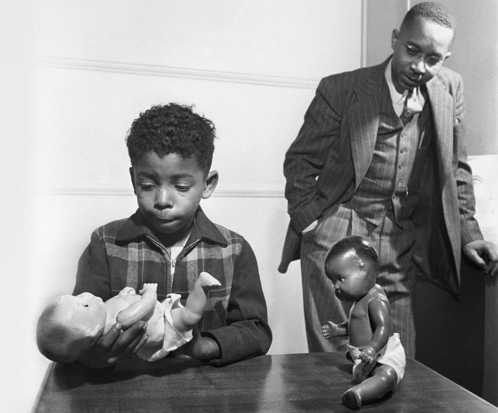 Dr Kenneth Clark watching boy hold baby doll